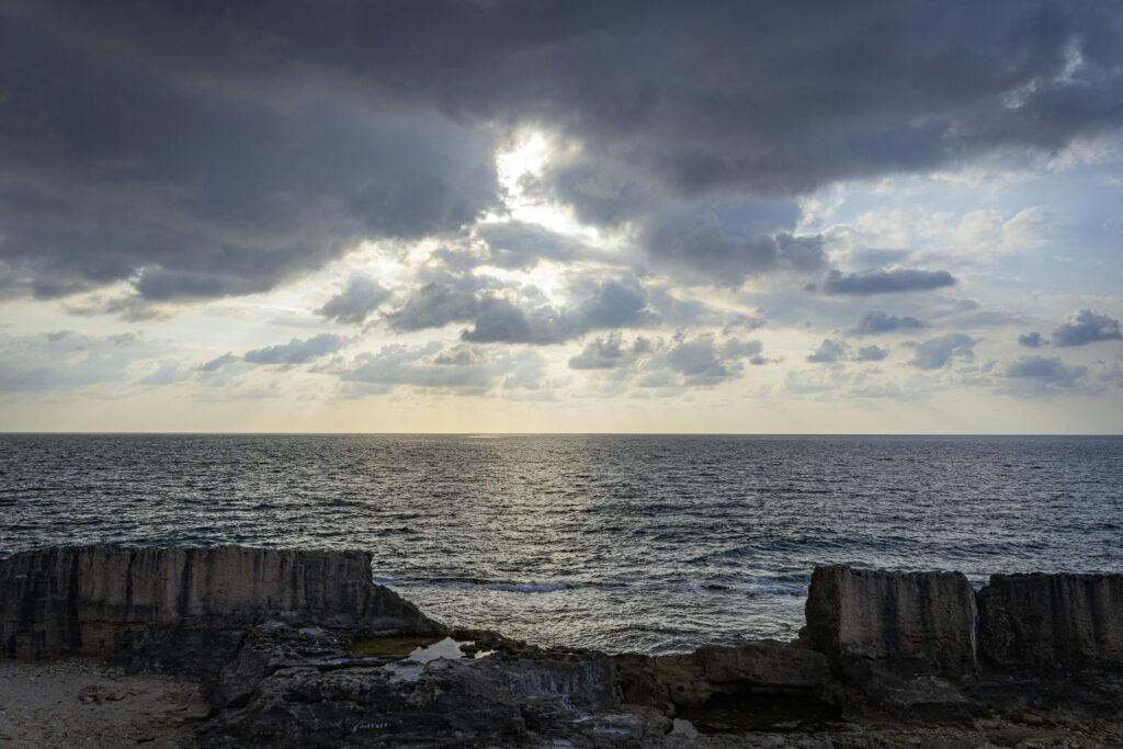 Dramatic clouds over the Mediterranean Sea and Phoenician wall in Batroun, Lebanon during sunset.
