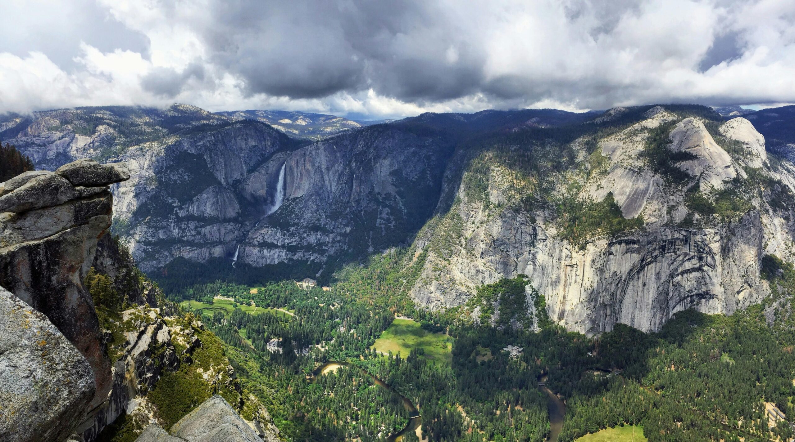 Beautiful view of Yosemite Valley with mountains, trees, and dramatic clouds in California.