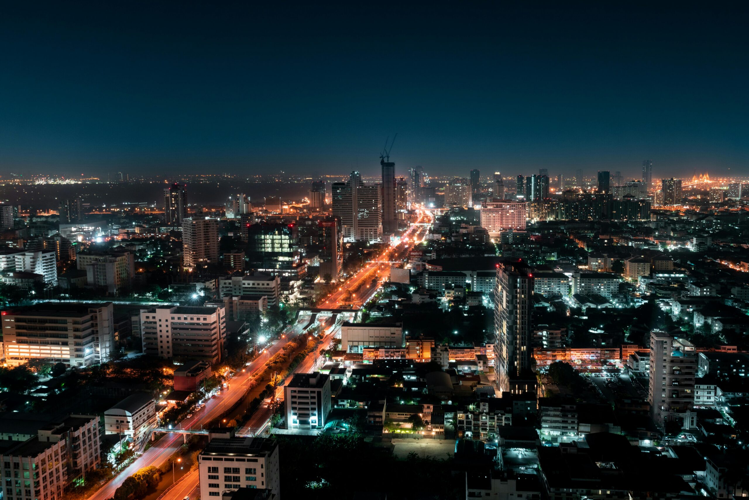 Explore the vibrant skyline of Bangkok with its illuminated skyscrapers and bustling streets captured at night.