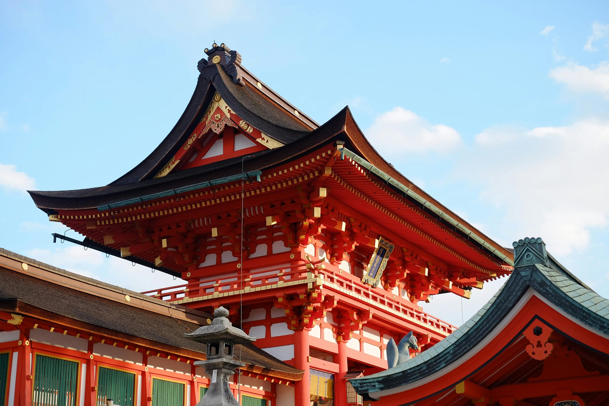 Captivating view of a traditional Shinto shrine in Kyoto, showcasing exquisite architecture beneath a blue sky.