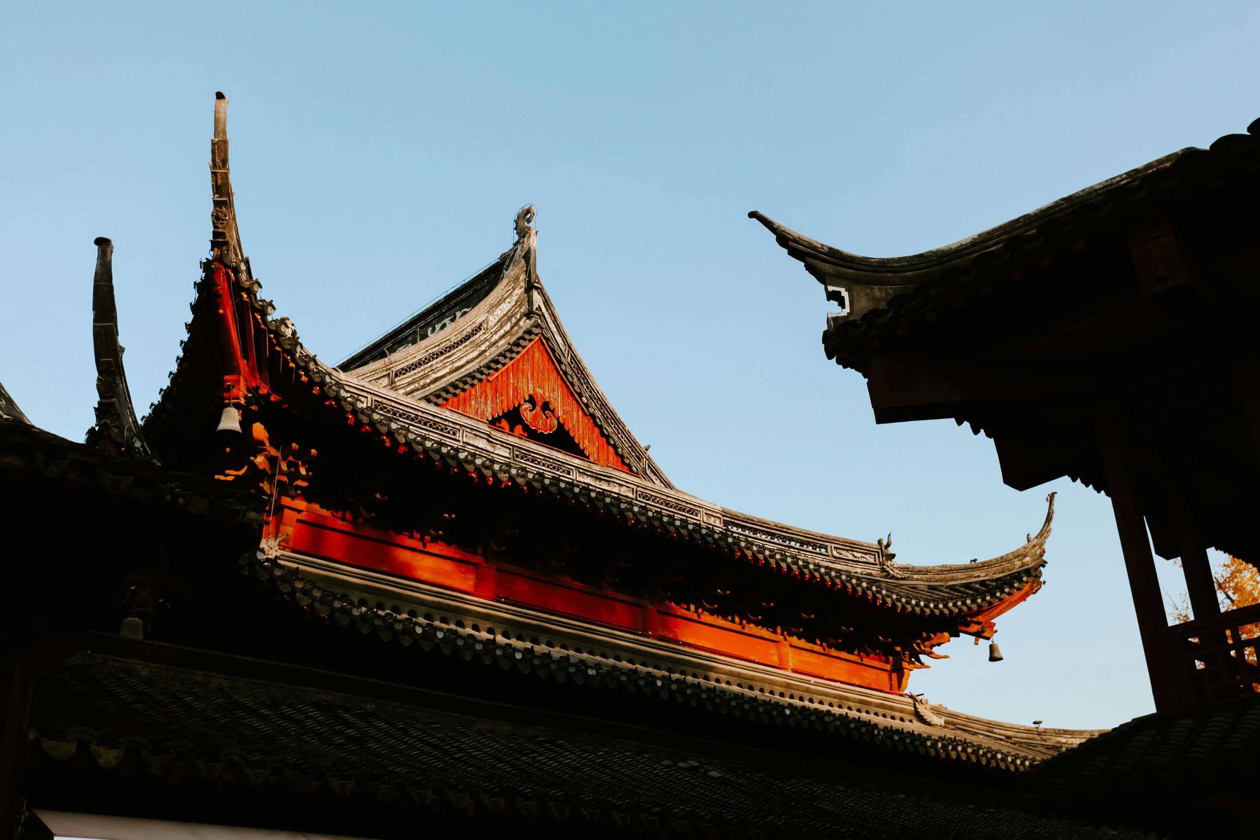 View of traditional Chinese temple roofs in Nanjing during autumn, showcasing intricate architectural details.